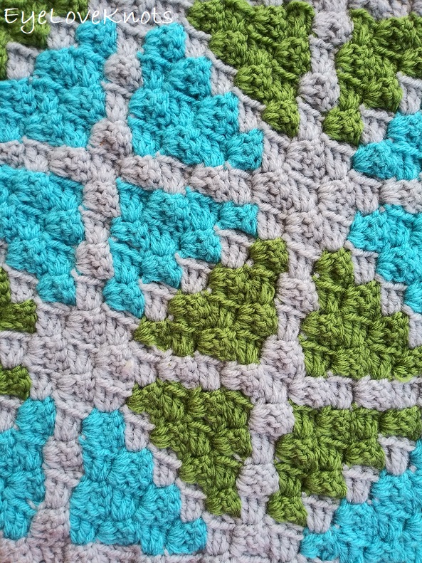 Close up of C2C Window Pane Square - a geometric print of blue and green triangles.