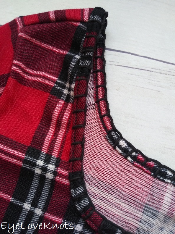 Close up of blanket stitch edging around neckline of plaid shirt