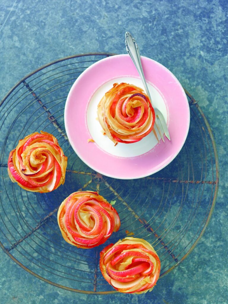 four cinnamon rose cupcakes on a cake plate