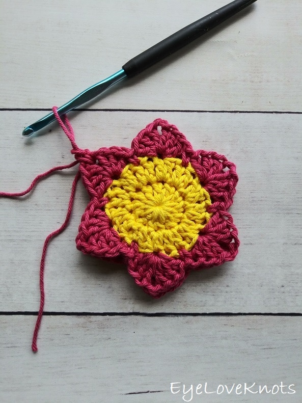 two pink and yellow crocheted flowers with one stitch joining the two layers, EyeLoveKnots